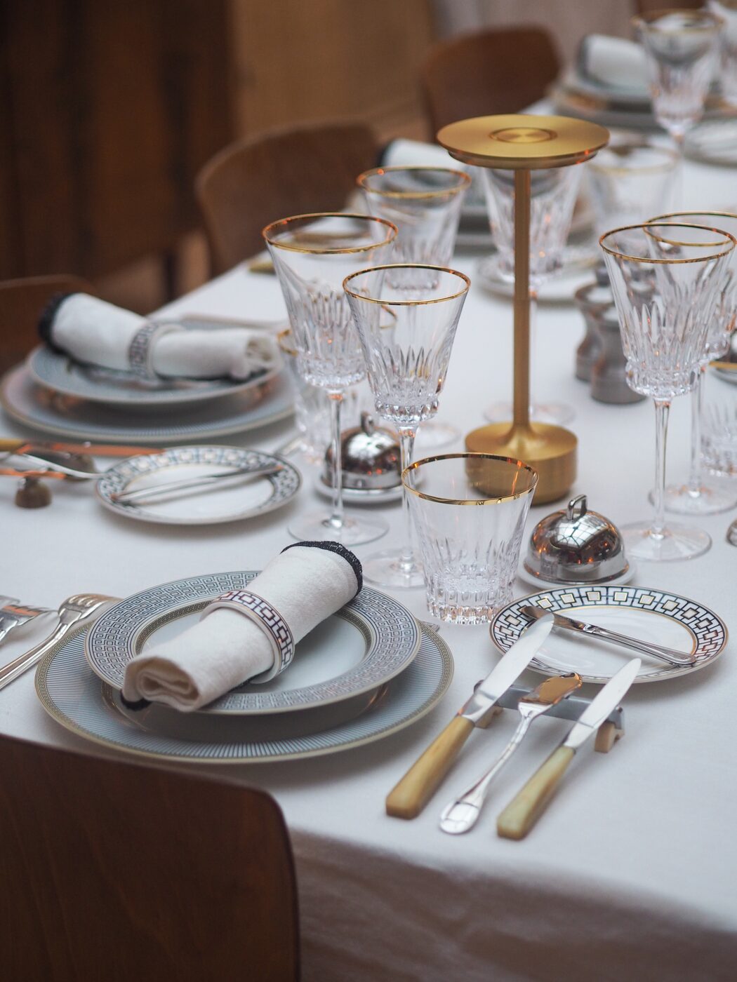 Table dressée avec art de la table Hermès, verres en cristal et chandelier doré